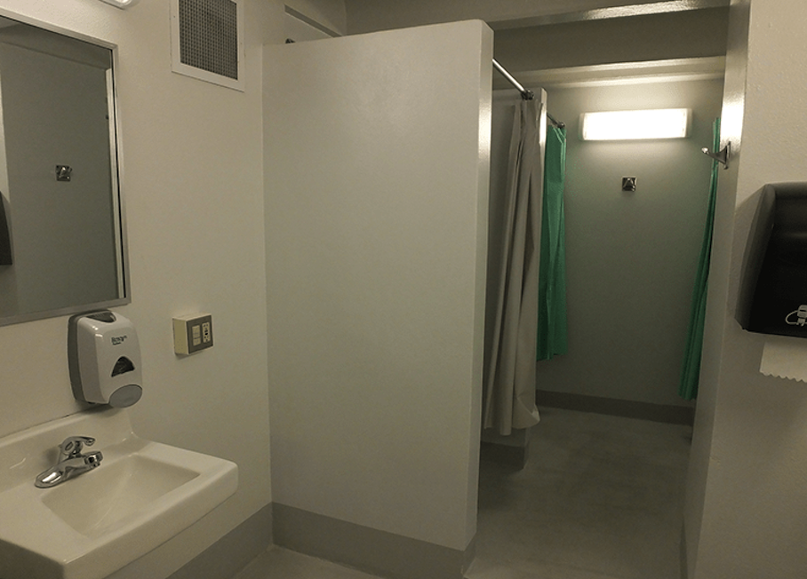 Community bathroom view of shower stalls.