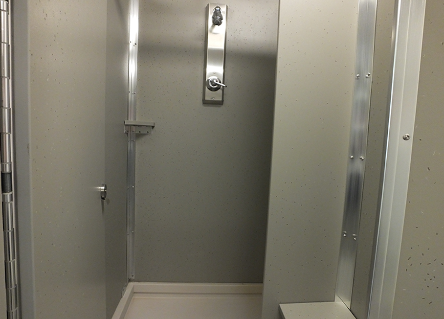 Community bathroom view of shower stalls