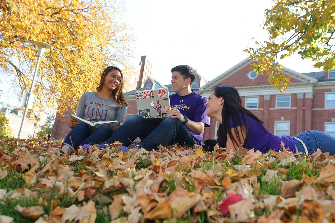 Students sitting outside in Autumn